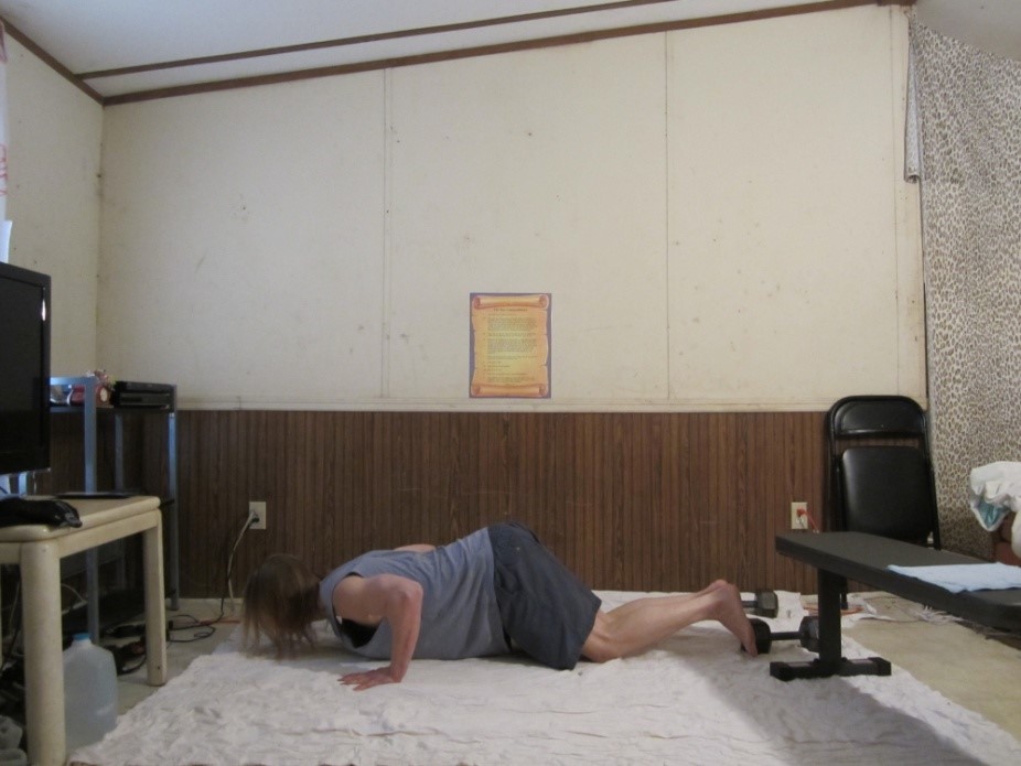 Bent knee push up picture demonstrating the middle of the repetition from a side viewpoint.