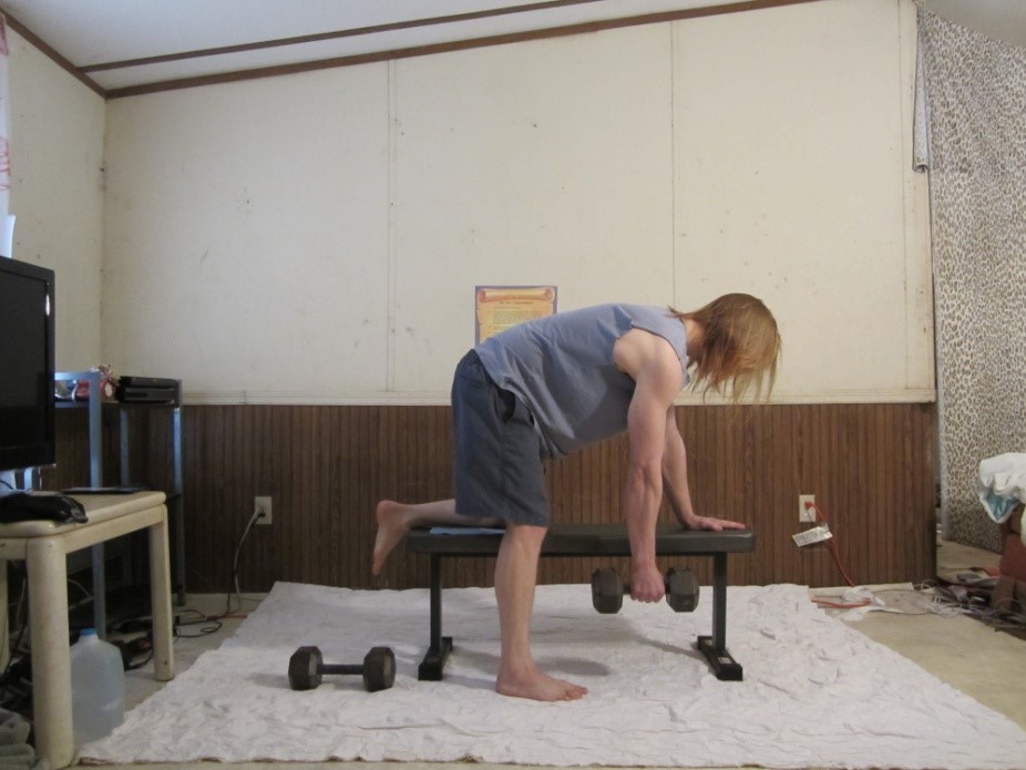 Dumbbell back row picture demonstrating the beginning of the repetition for the right arm from a side viewpoint.