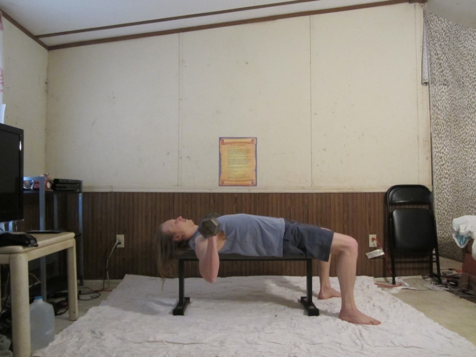 Dumbbell bench press picture demonstrating the end of the repetition from a side viewpoint.