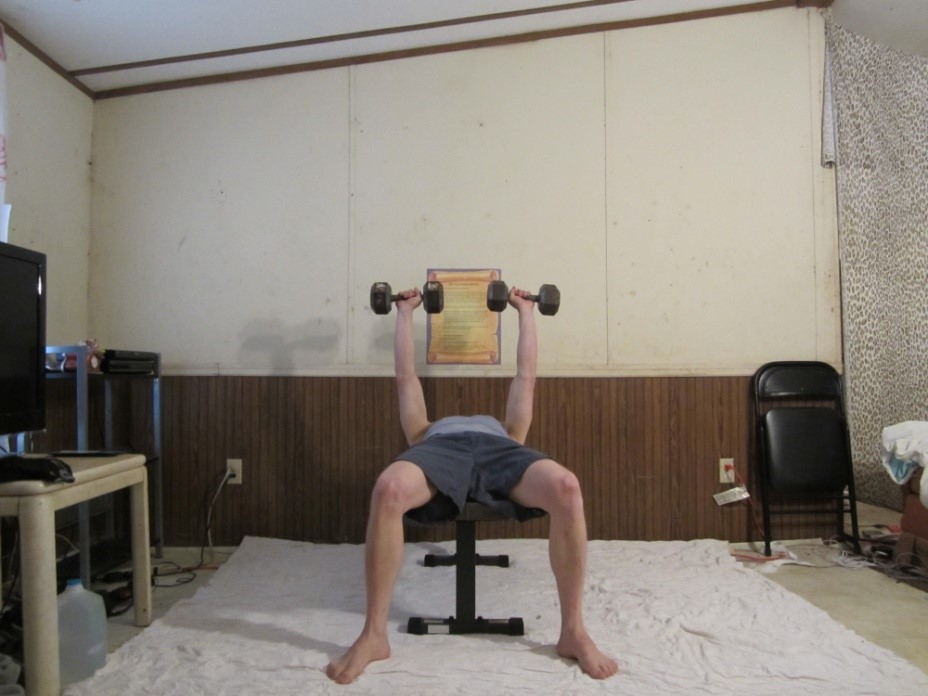 Dumbbell bench press picture demonstrating the middle of the repetition from a front viewpoint.